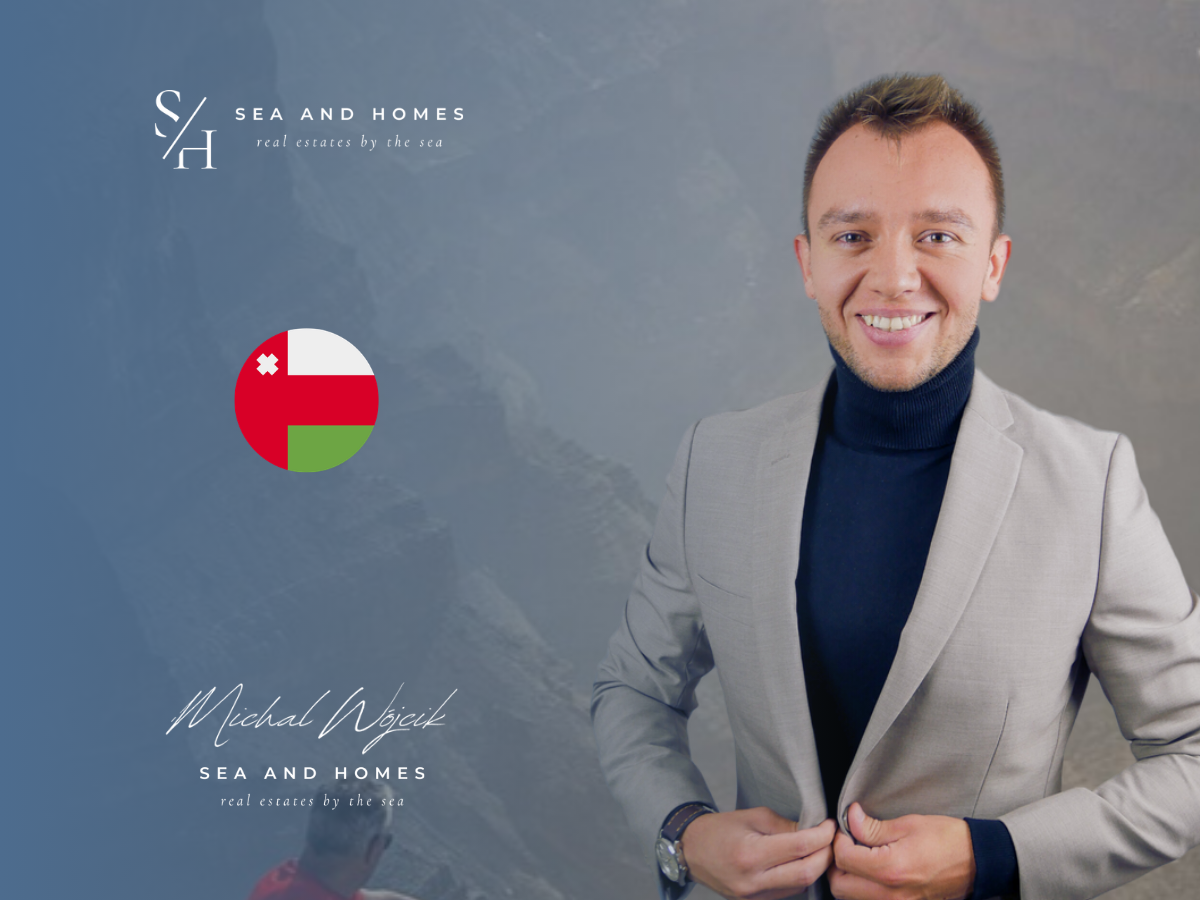 Michał Wójcik, Sea and Homes, na tle gór Jebel Shams w Omanie z plakietką flagi Omanu – baner artykułu o dziedziczeniu nieruchomości w Omanie 2026
