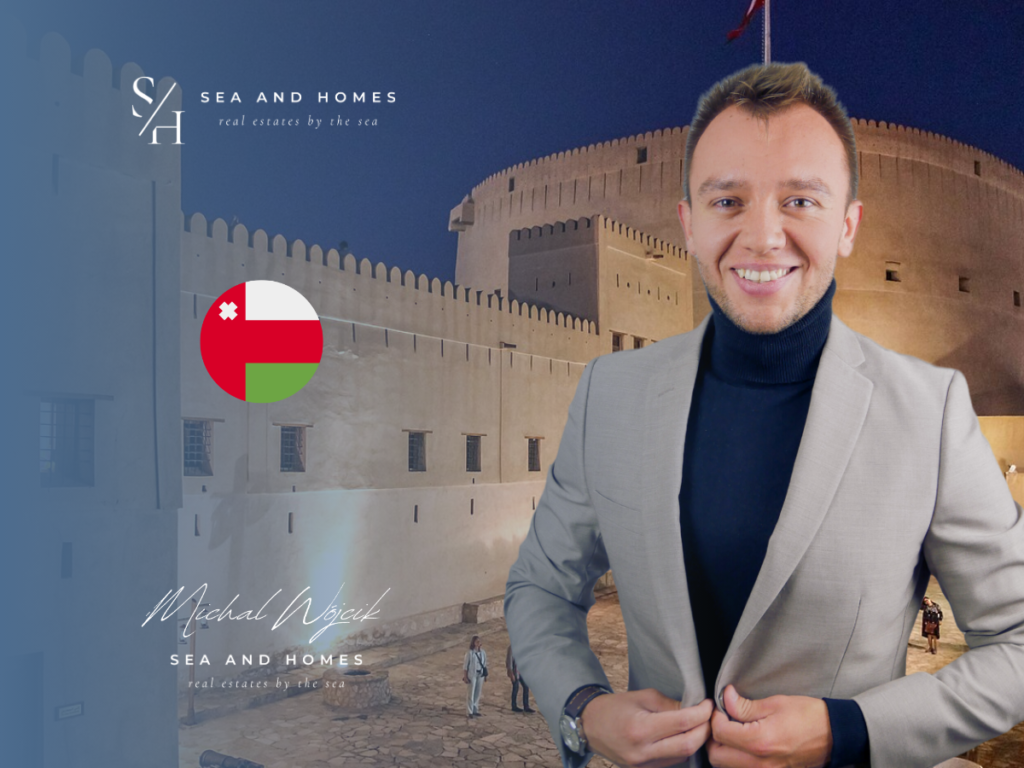 Podatki od nieruchomości w Omanie 2026 - baner Sea and Homes, forteca w Nizwie nocą i flaga Omanu